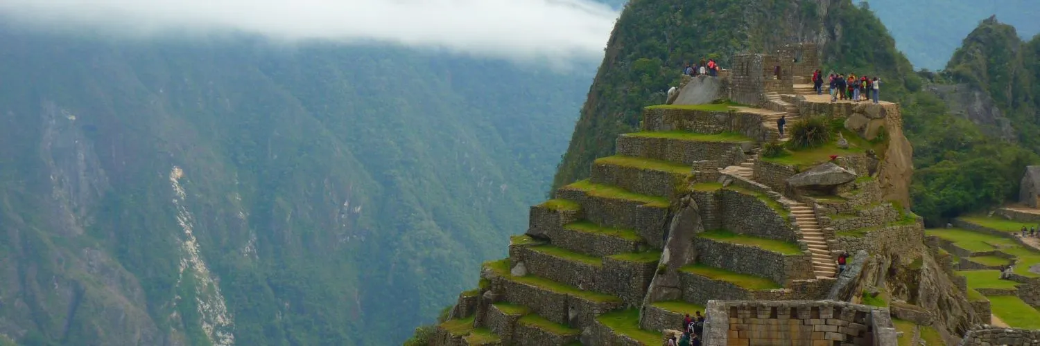 Vista panorámica de Machu Picchu, con sus imponentes terrazas y montañas verdes, capturando la majestuosidad de la Ciudadela Inca.