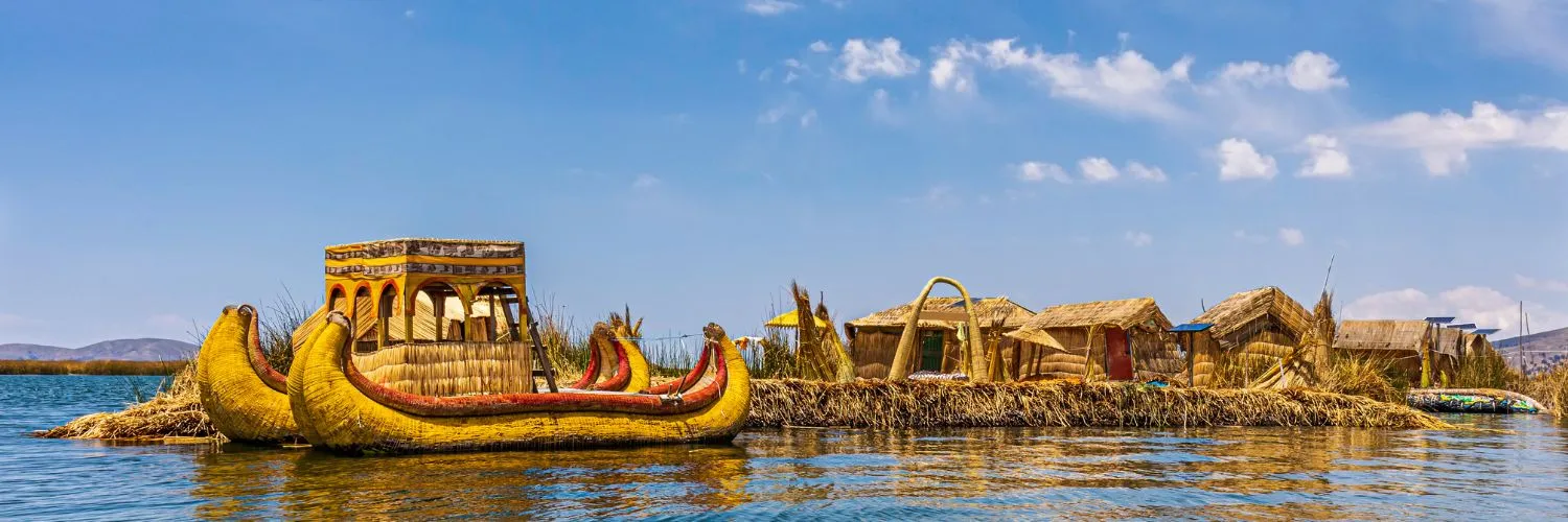 Vista panorámica del Lago Titicaca en Puno, Perú, con las islas flotantes de los Uros y sus coloridas embarcaciones tradicionales.